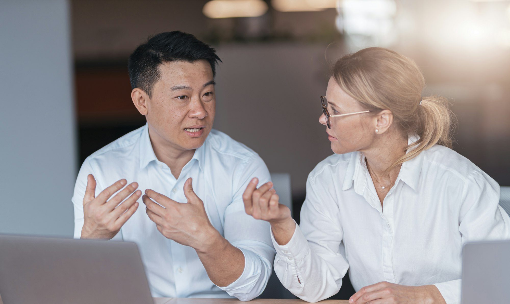 Focused female employee discussing online project, showing presentation to skilled team leader